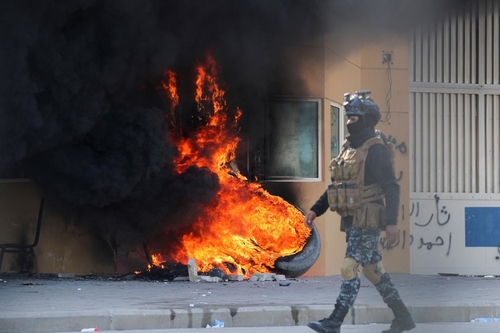 A member of Iraqi security forces walks past the U.S. Embassy in Baghdad, Iraq, January 2020 (Thaier Al-Sudani / Reuters) 